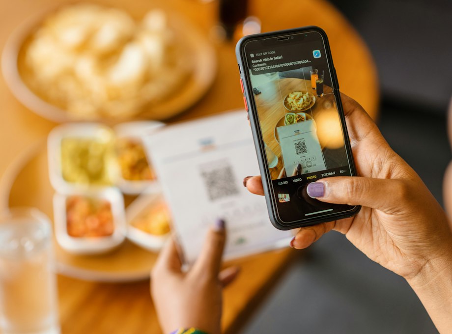 Une commerçante photographie un ticket de caisse avec son téléphone