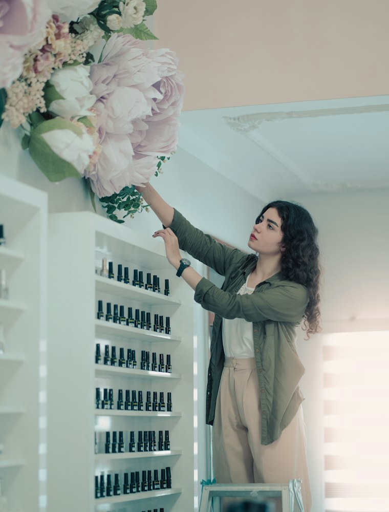 Une commerçante réassortit les rayons de sa boutique