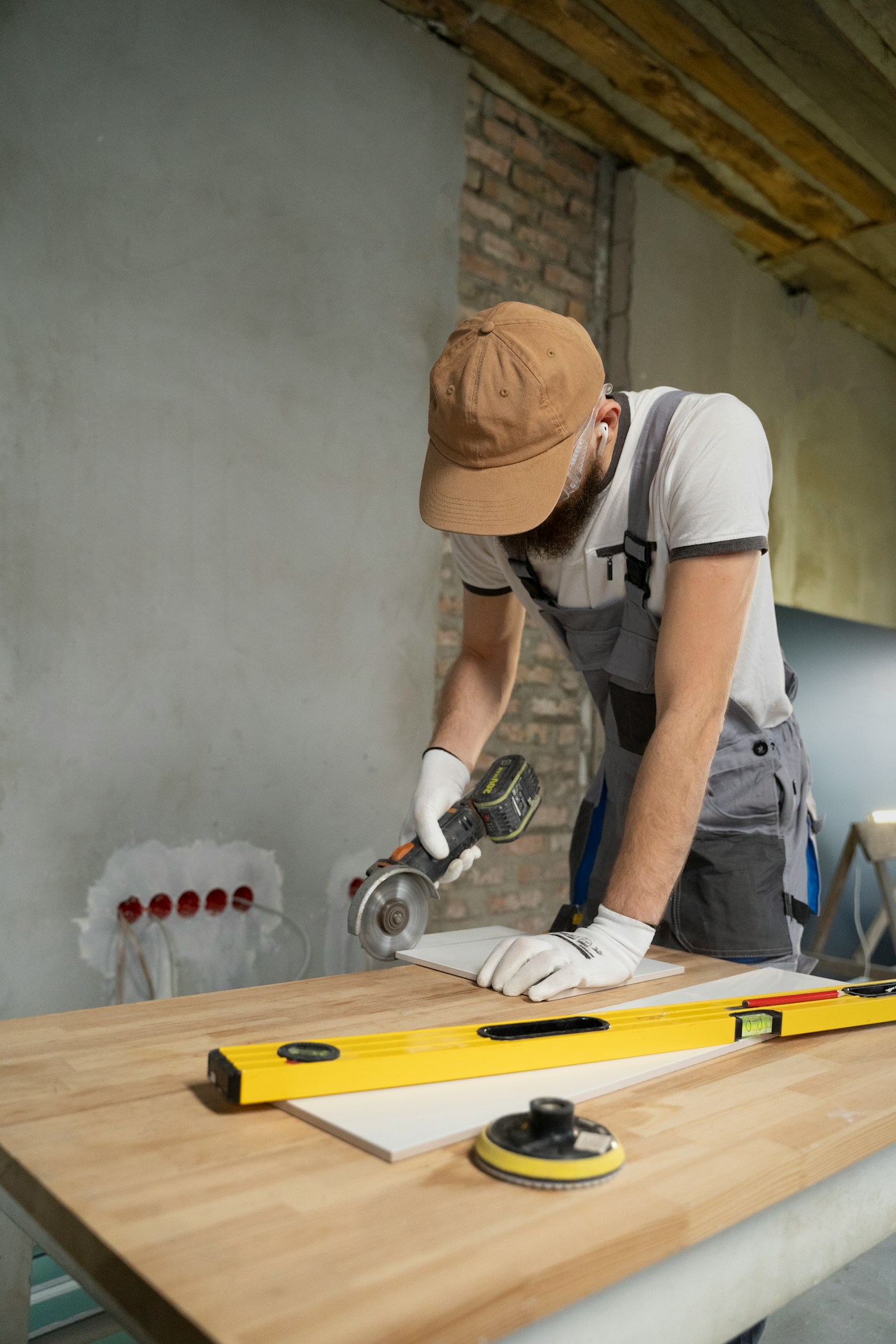 Un artisan découpe un carreau sur un chantier de rénovation